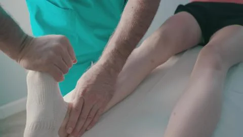 A physio gives myotherapy using trigger points on athlete woman Stock Photos
