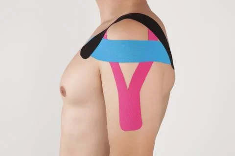 Physio taping on man shoulder Stock Photos