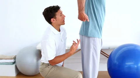 Physiotherapist checking the lower back of patient Stock Footage 34669263