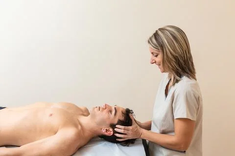 Physiotherapist does session to man. cervical manipulation, trapezium stretch Stock Photos
