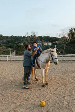 Physiotherapist doing an exercise with a child with a disability in an equine Stock Photos