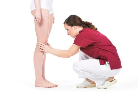 Physiotherapist doing a knee evaluation Stock Photos