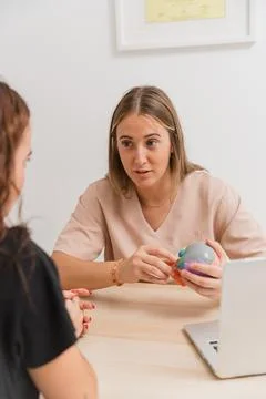 Physiotherapist explaining treatment using anatomical model to patient Stock Photos