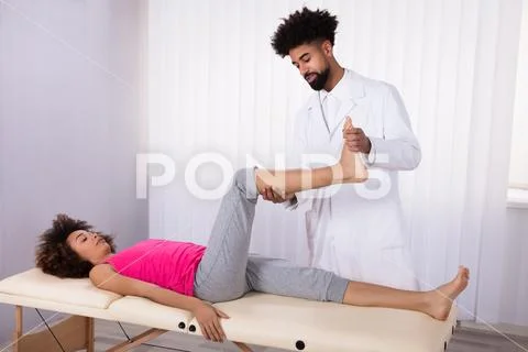 Physiotherapist Giving Leg Exercise To Patient Stock Photos