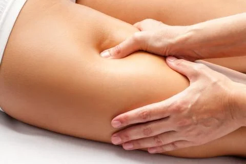 Physiotherapist hands massaging hamstring on athlete. Stock Photos