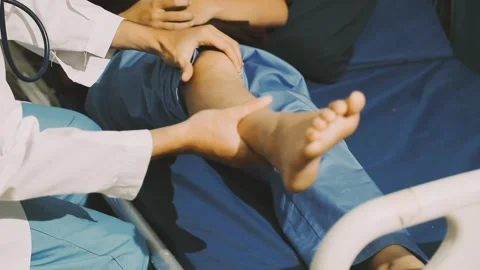 Physiotherapist performing a knee exercise for a patient Stock Footage 325966696