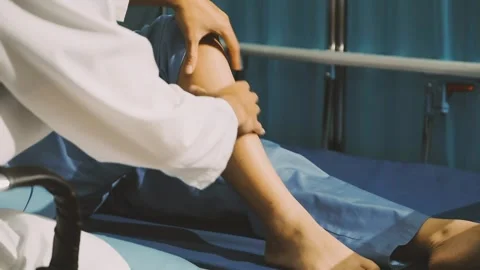 Physiotherapist performing a knee exercise for a patient Stock Footage 325966702