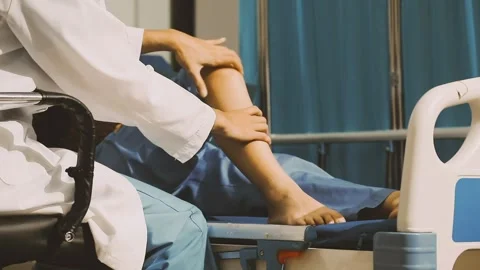 Physiotherapist performing a knee exercise for a patient Stock Footage 325966703