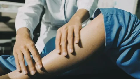 Physiotherapist performing a knee exercise for a patient Stock Footage 325966707