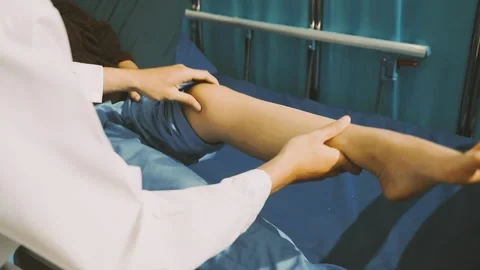 Physiotherapist performing a knee exercise for a patient Stock Footage 325966718