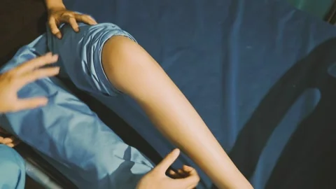 Physiotherapist performing a knee exercise for a patient Stock Footage 325966720