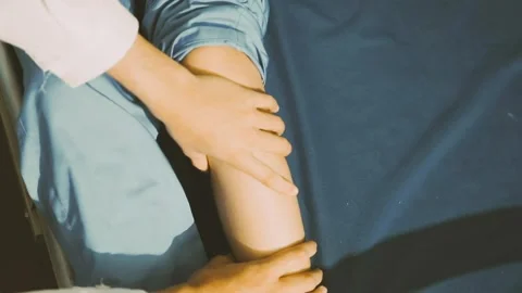 Physiotherapist performing a knee exercise for a patient Stock Footage 325966721