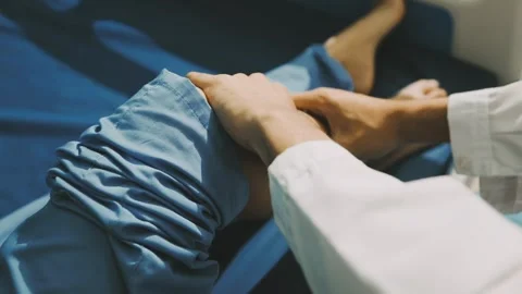 Physiotherapist performing a knee exercise for a patient Stock Footage 325966729