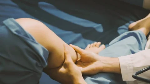 Physiotherapist performing a knee exercise for a patient Stock Footage 325966730