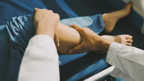 Physiotherapist performing a knee exercise for a patient Stock Footage 325966734
