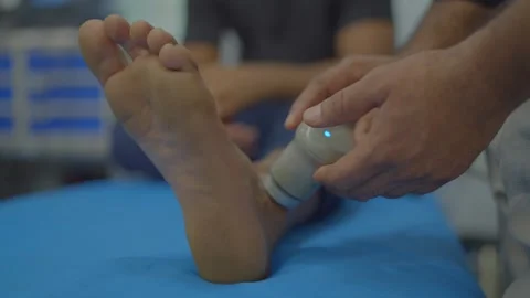 Physiotherapist puting gels with machine on patient ankle pain relief in hos.. Stock Footage 312256335