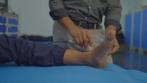 Physiotherapist puting gels on patient ankle pain relief Video stock 312256229