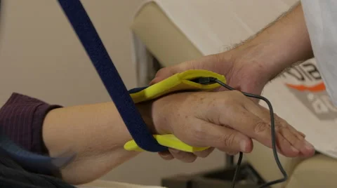 Physiotherapist puts device for electrotherapy massage on injured hand of woman. Video stock 59519369