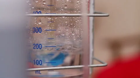 Physiotherapy equipment. Clear liquid bubbling in a glass retort 库存影片 64018691