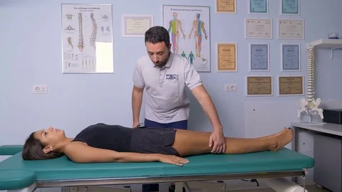 Physiotherapy session: physiotherapist puts the patient in position Stock Footage 82008554