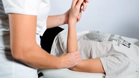 Physiotherapy on the wrist of a boy Stock Footage 98793802