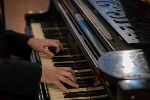 Pianist's hands in close-up while playing the piano. Piano keys during a clas Stock Photos
