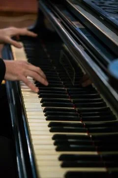 Pianist's hands in close-up while playing the piano. Piano keys during a clas Stock Photos