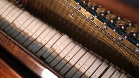 Piano hammer striking string, revealing delicate internal musical mechanism in Video stock 343847393