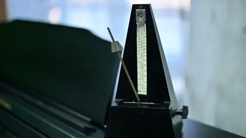 Piano with mechanical metronome, pendulum in motion. Stock Footage 335881609