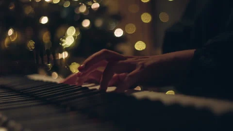 Piano Player Hands Playing In front of Christmas Holiday Tree and Lights Bokeh Stock Footage 321376960