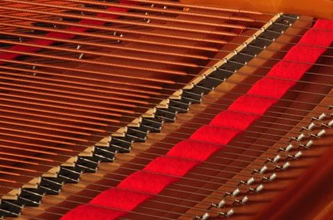 Piano strings with red felt. Stock Photos