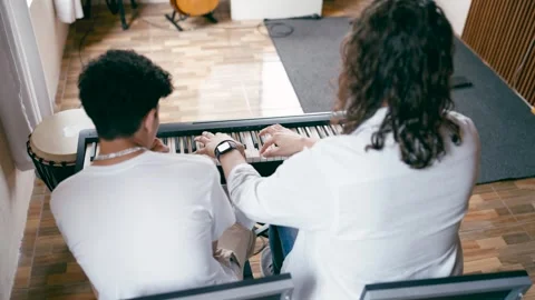 Piano teacher instructing student during music lesson Stock Footage 332155096