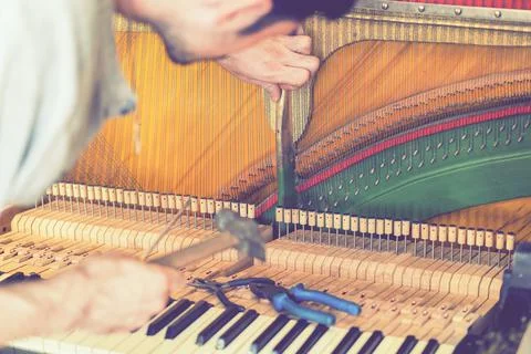 Piano tuning process. closeup of hand and tools of tuner working on grand pia Stock Photos