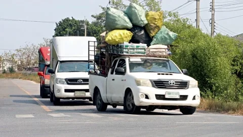 A pick up car loaded with many sacks turns at the crossroads Stock Footage 234466636