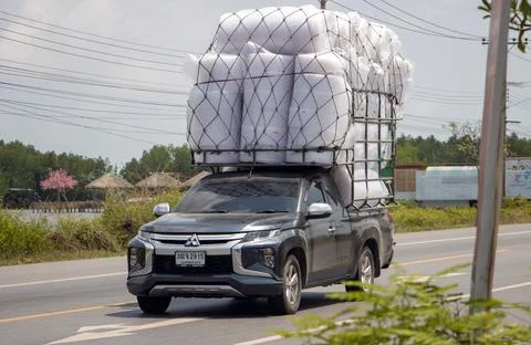 A pick up car loaded with many sacks of fabric ride on a road Stock Photos