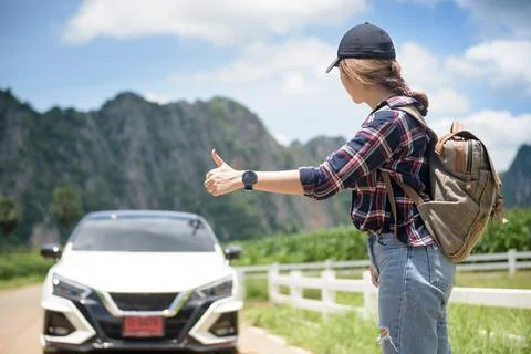 Pick me up. Backpacking lady on the side of the road. Woman trying to stop. T Stock Photos