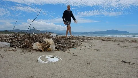 Pick up plastic pieces found on the beach to help environment 4608 Stock Footage 107950983