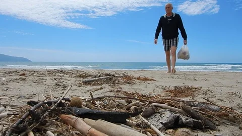 Pick up plastic pieces found on the beach to help environment 4612 Stock Footage 107951101