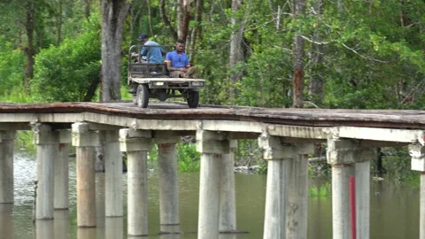 Pick-up truck loading workers across a wooden bridge Stock Footage 230907152