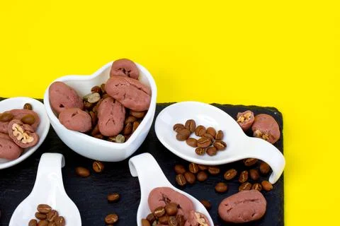 Pickan nuts and coffee beans, yellow background. Macro concept. As a packagin Stock Photos