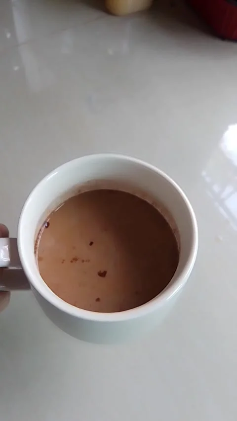 Picked up a white cup containing coffee as if I was about to drink it, but then Vídeos de archivo 238836724