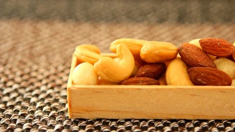 Picking almond form mixed nuts in box, in studio Chiangmai Thailand Stock Footage 104540965
