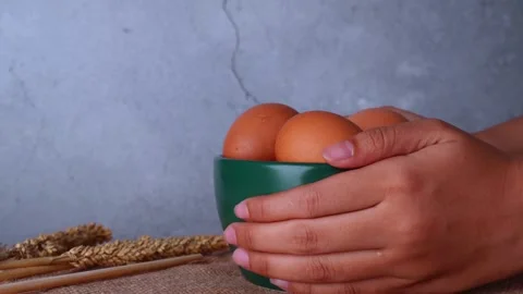 Picking up and putting down a green bowl of eggs by hand 库存影片 273277857
