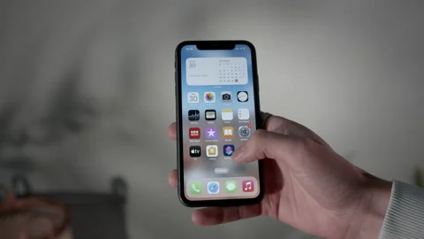 Picking up and unlocking iPhone with IOS 16, swiping then putting it away, Stock Footage 217767795