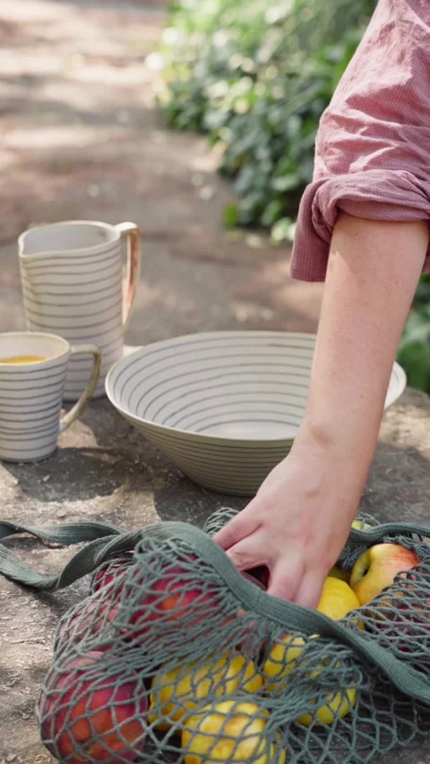 Picking Apples from a Basket on a Garden Table Stock Footage 340670224