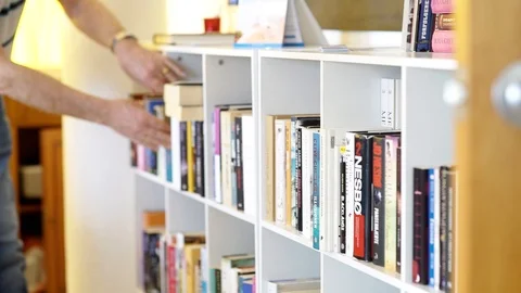 Picking a book Vídeos de archivo 89693496