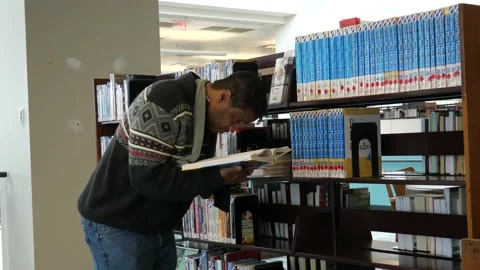 Picking books in Library Video stock 171340526