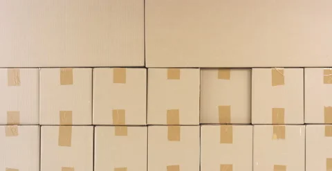 Picking a box out of stack of cardboard boxes with goods in a warehouse. 6K Stock Footage 134560071