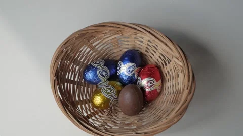 Picking Colorful Easter Egg Chocolates from a Wicker Basket Stock Footage 331906093
