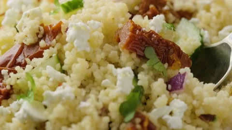 Picking Couscous salad with sun dried tomatoes, cucumber, red onion and feta Stock Footage 159585571
